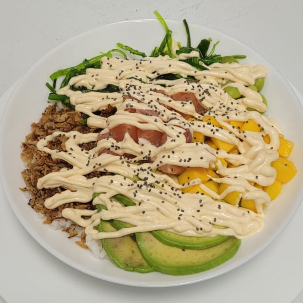 Poke Salmón Base de Arroz acompañada de Salmon Fresco ,Edamame, Wakame, Mango , Aguacate y Cebolla Crujiente con salsa Spicy Mayo
