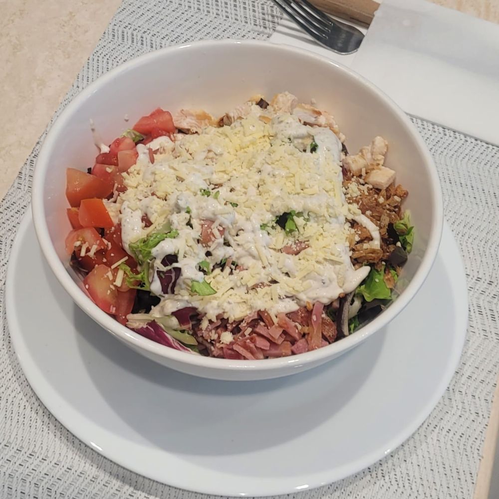 Ensalada César Base de Mix de Lechuga acompañada de Tomate, Bacon Crujiente, Pollo Plancha, Cebolla Crujiente y Queso Rayado con Salsa César
